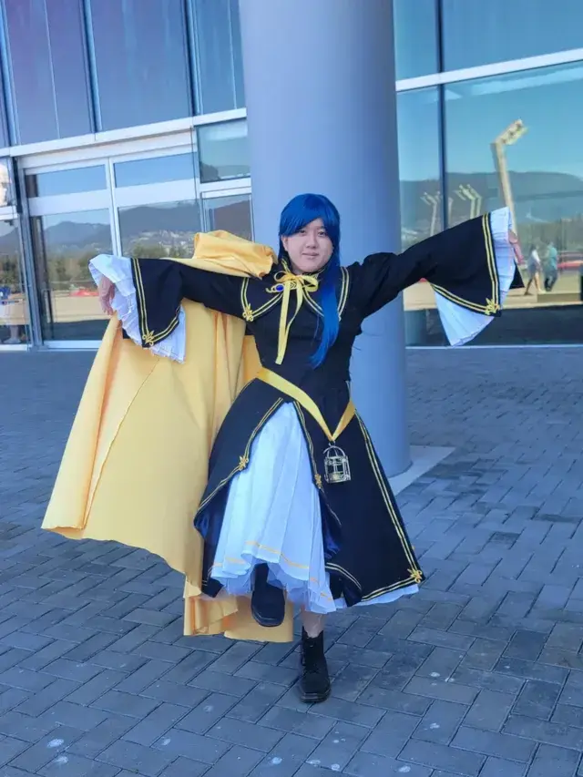 Rozmyne cosplay in front of convention center, glico pose